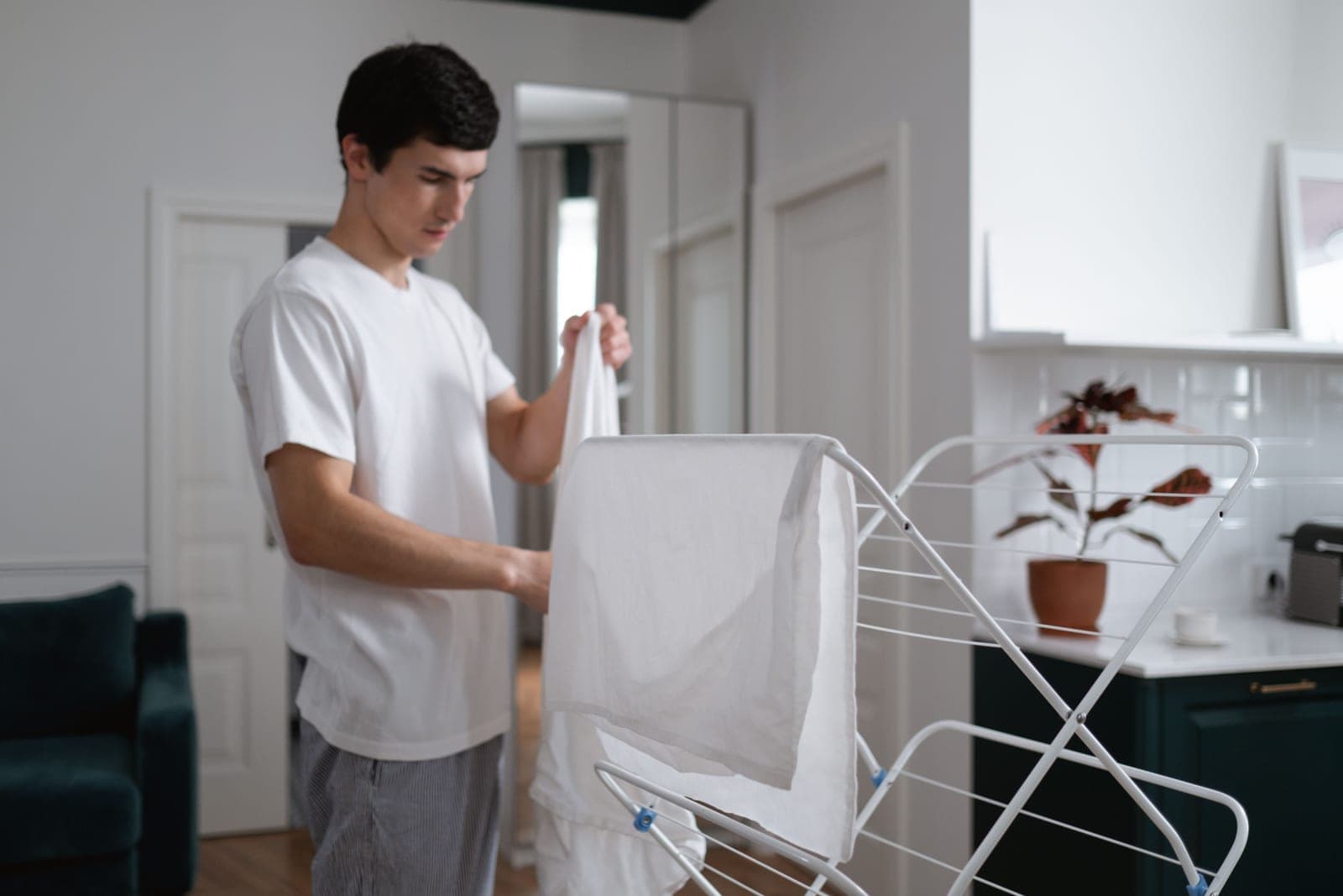 A person arranging laundry on a drying rack in a modern room