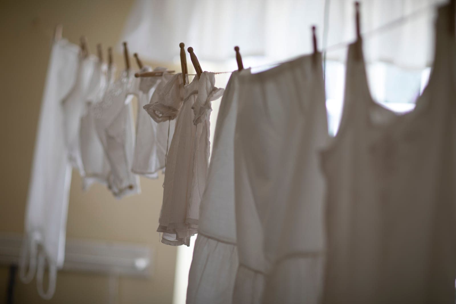 A row of white laundry hanging indoors in soft light