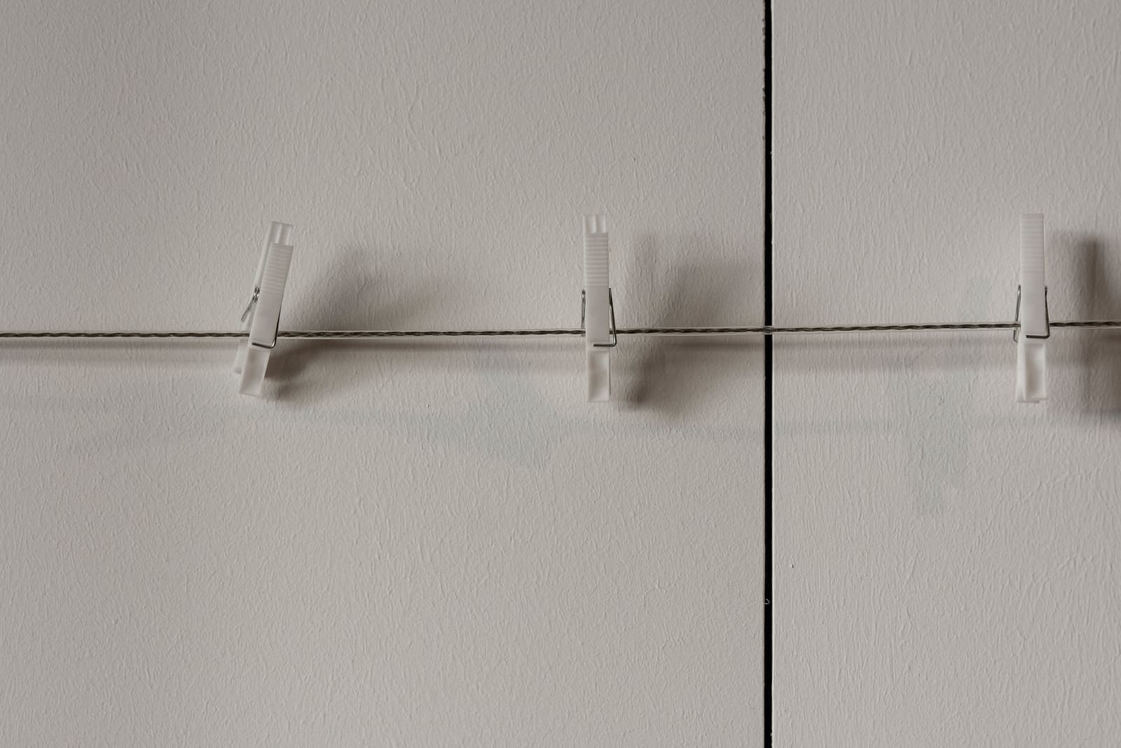 Laundry line with clothespins against a clear sky
