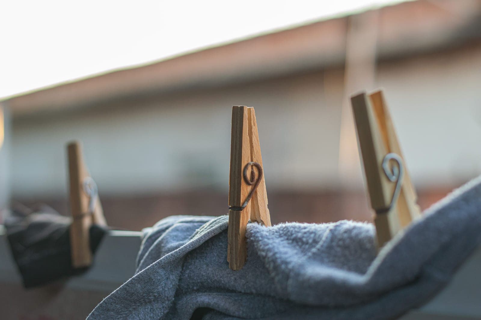 Wooden clothespins gripping laundry on an outdoor line