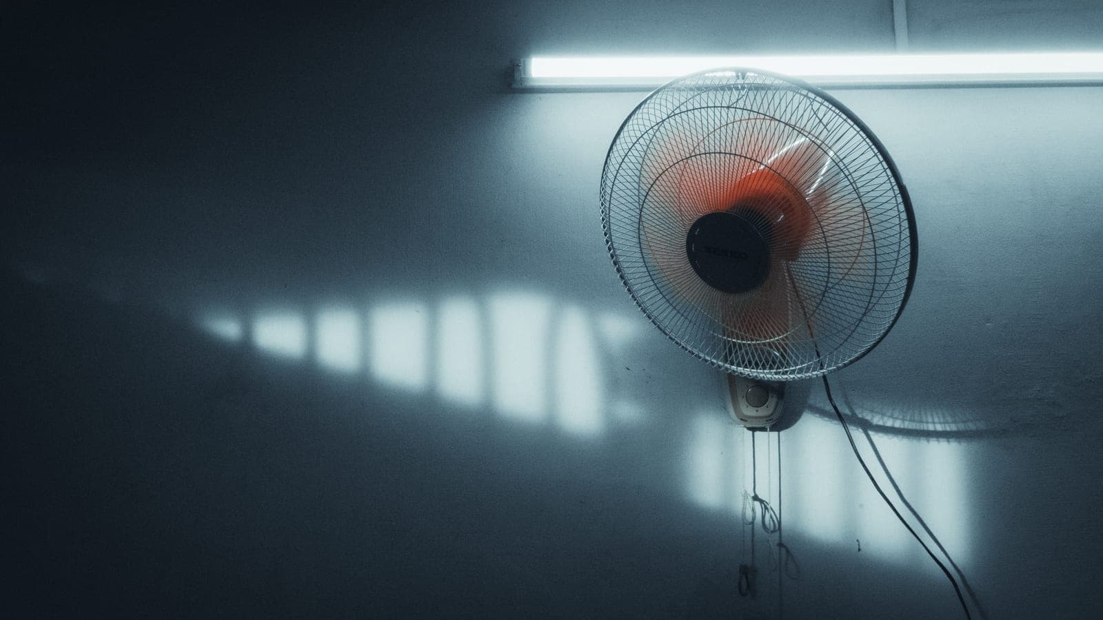 An electric fan standing in a bright room
