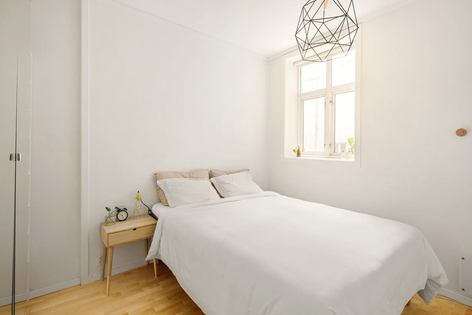 A bright, tidy bedroom with white walls