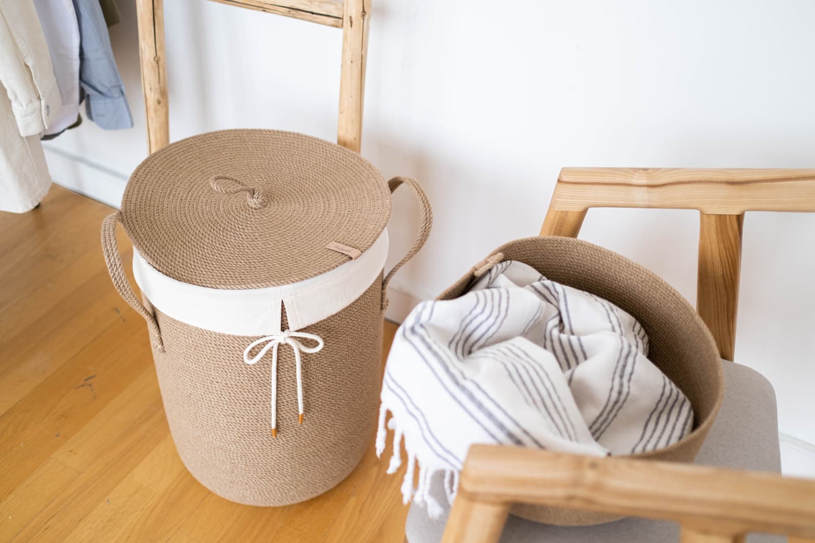 A stylish laundry corner with a woven basket and folded striped cloth