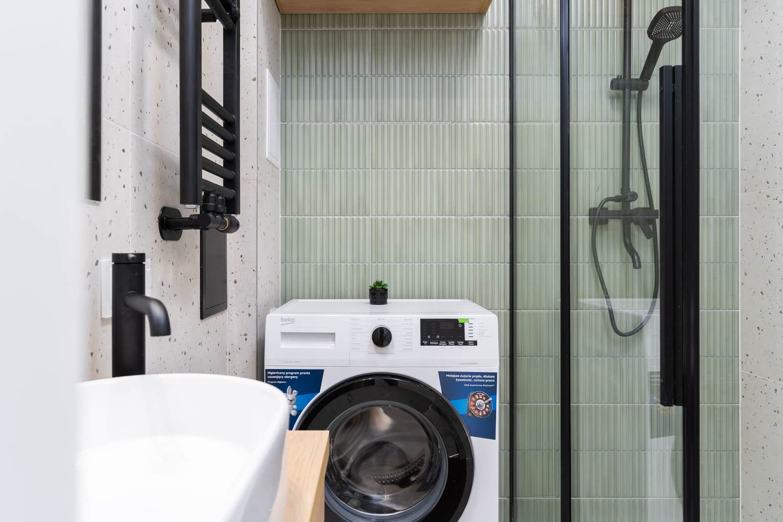 A compact laundry machine in a small modern apartment washroom