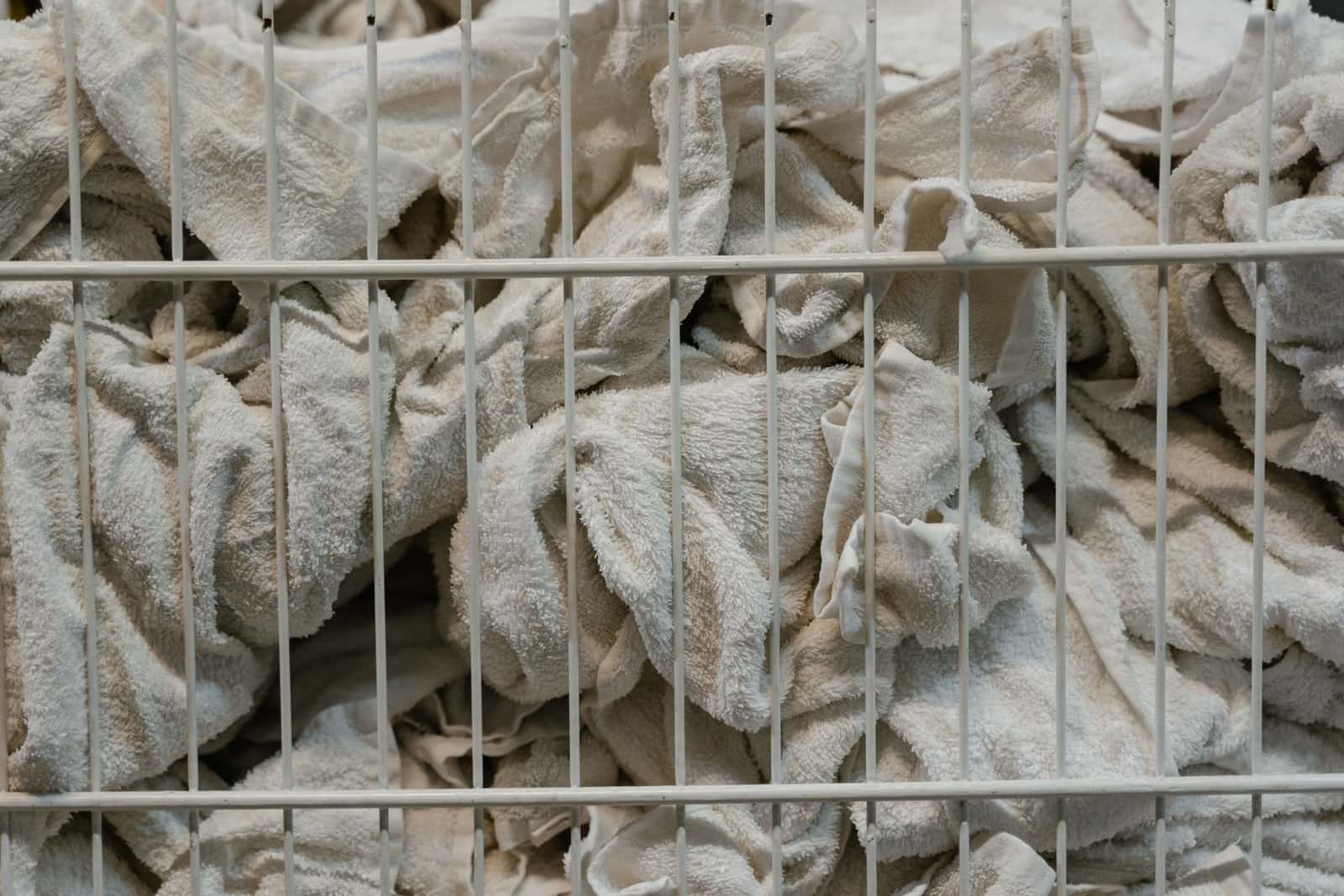 White towels stacked in a wire laundry basket