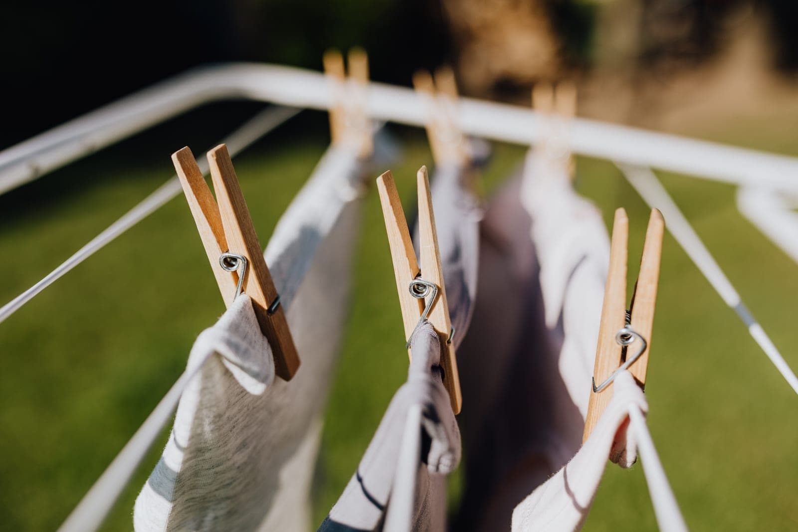 Laundry pegged to a metal folding clothes airer in bright daylight