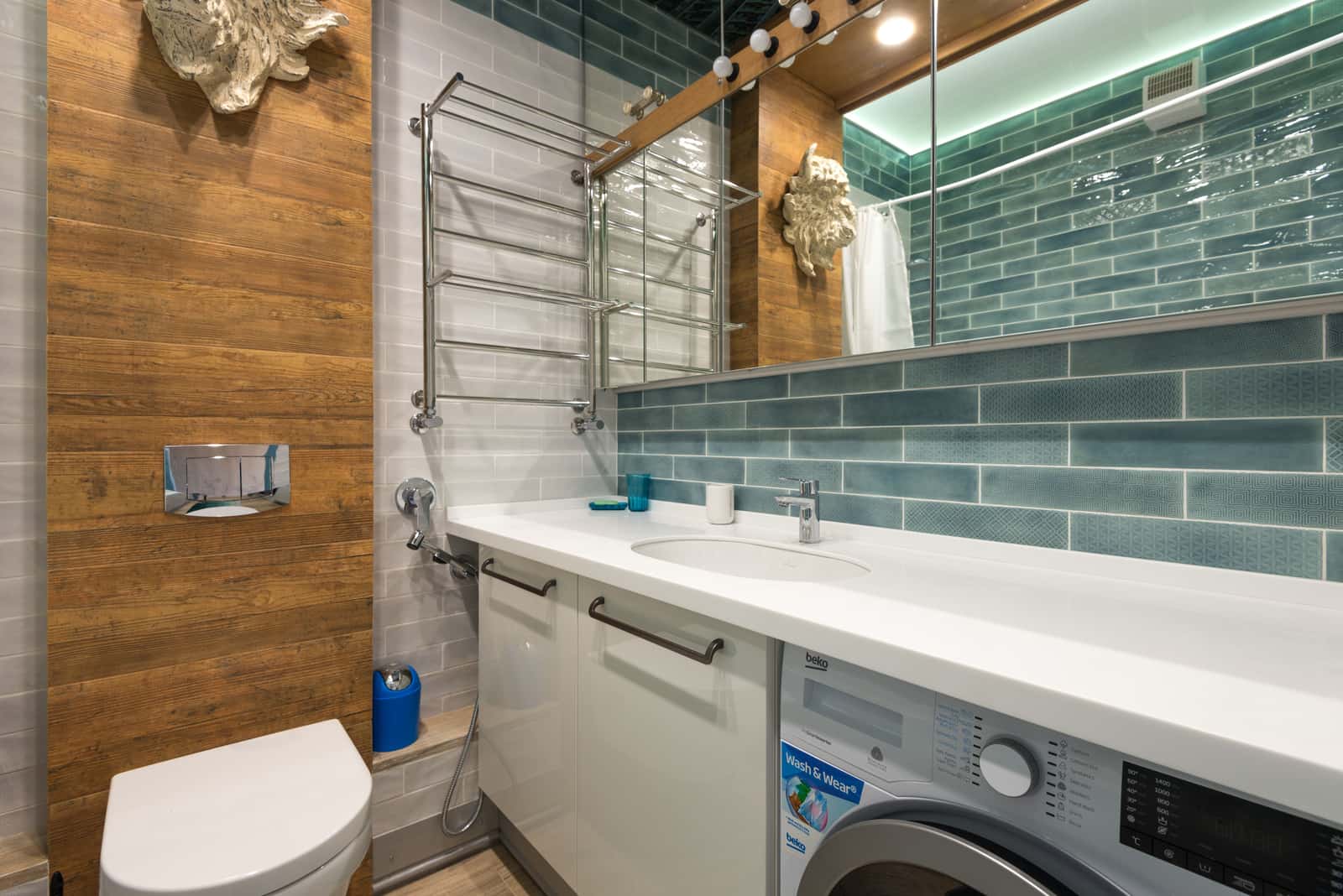 A heated towel rail holding folded towels in a bright bathroom
