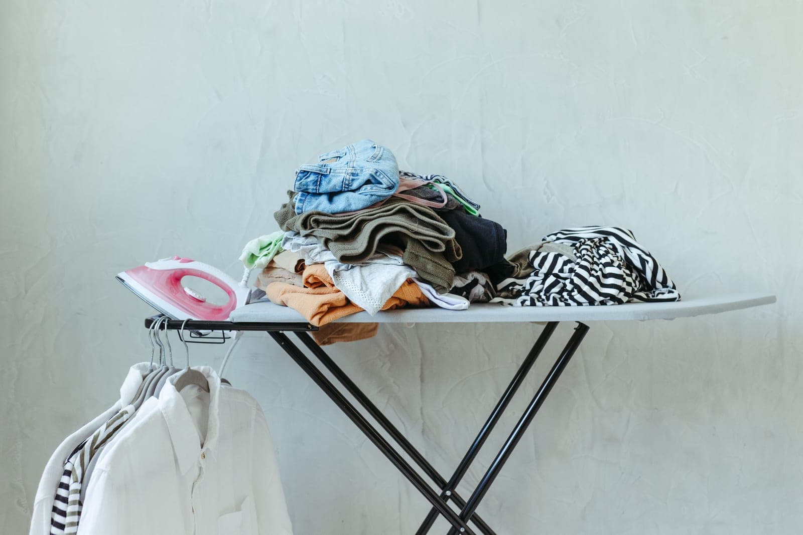 Sorted laundry and hanging white shirts in a bright utility space