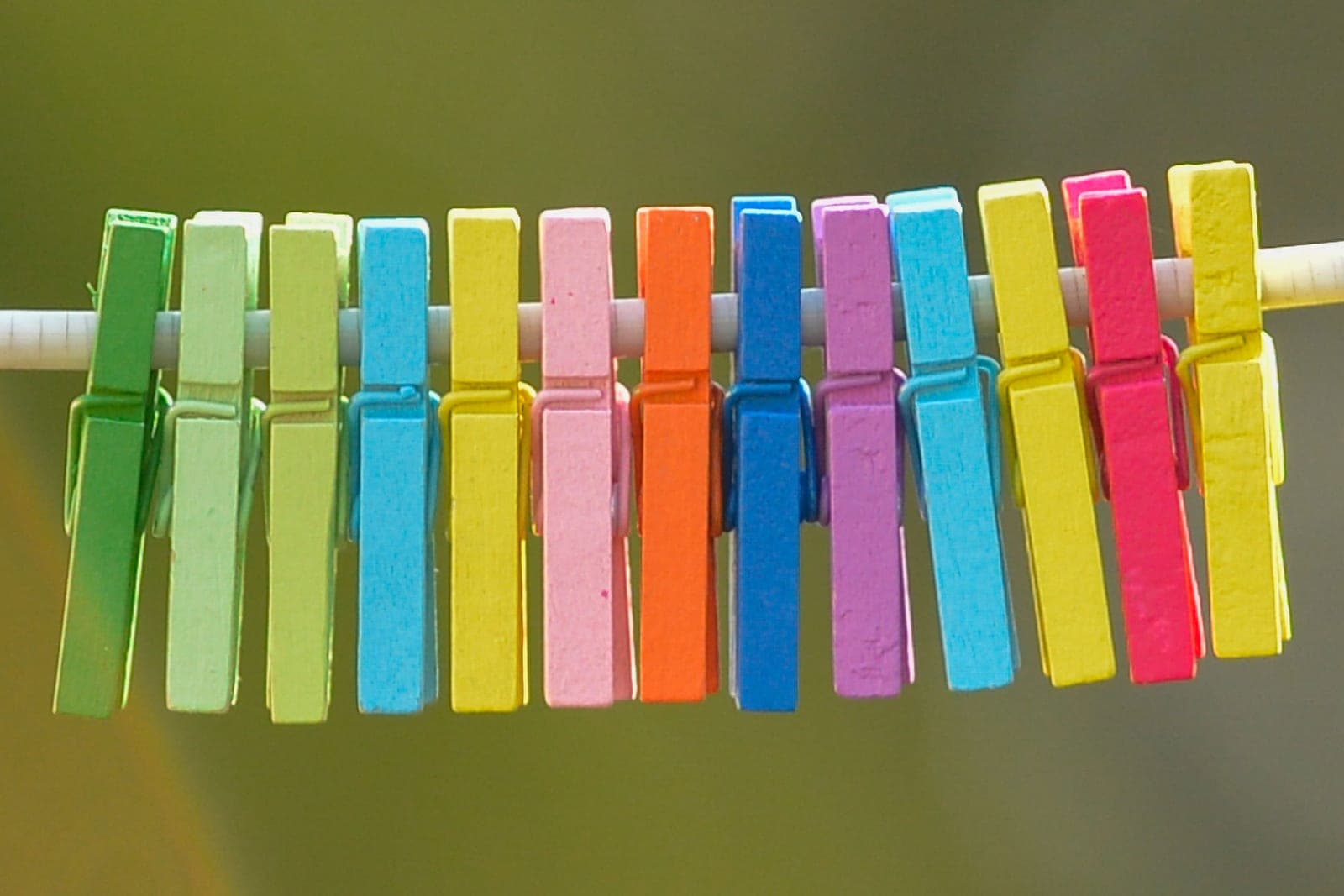 Colorful wooden clothespins on a drying line in bright daylight