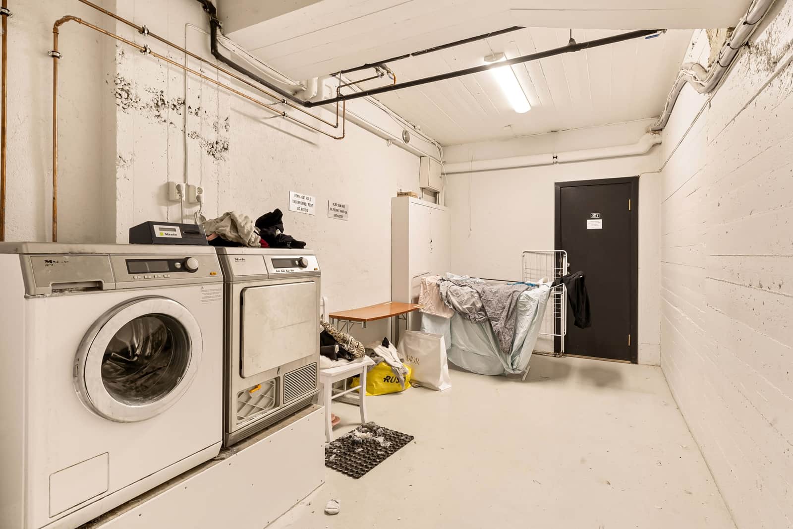 A bright laundry room interior with machines and space to dry